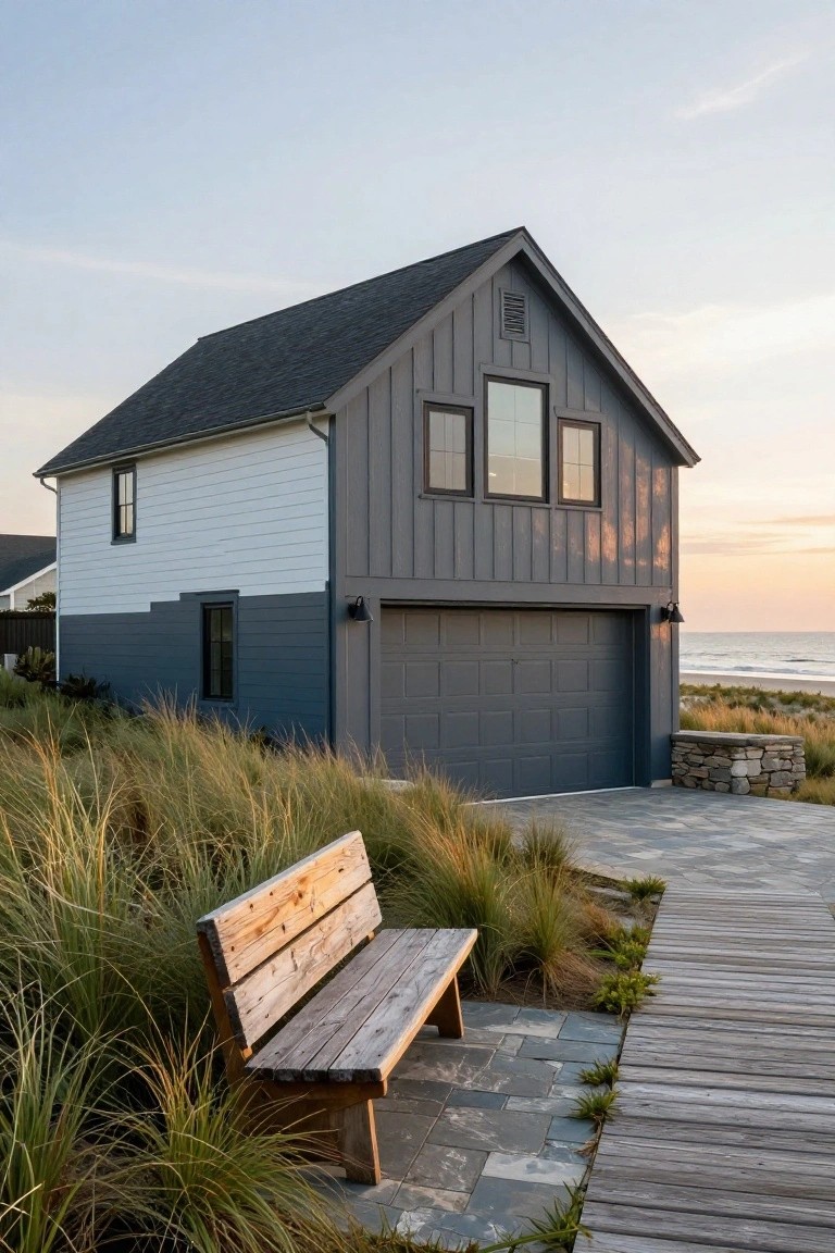 Garage exterior painted deep cool gray with white accents and wood bench on a coastal path