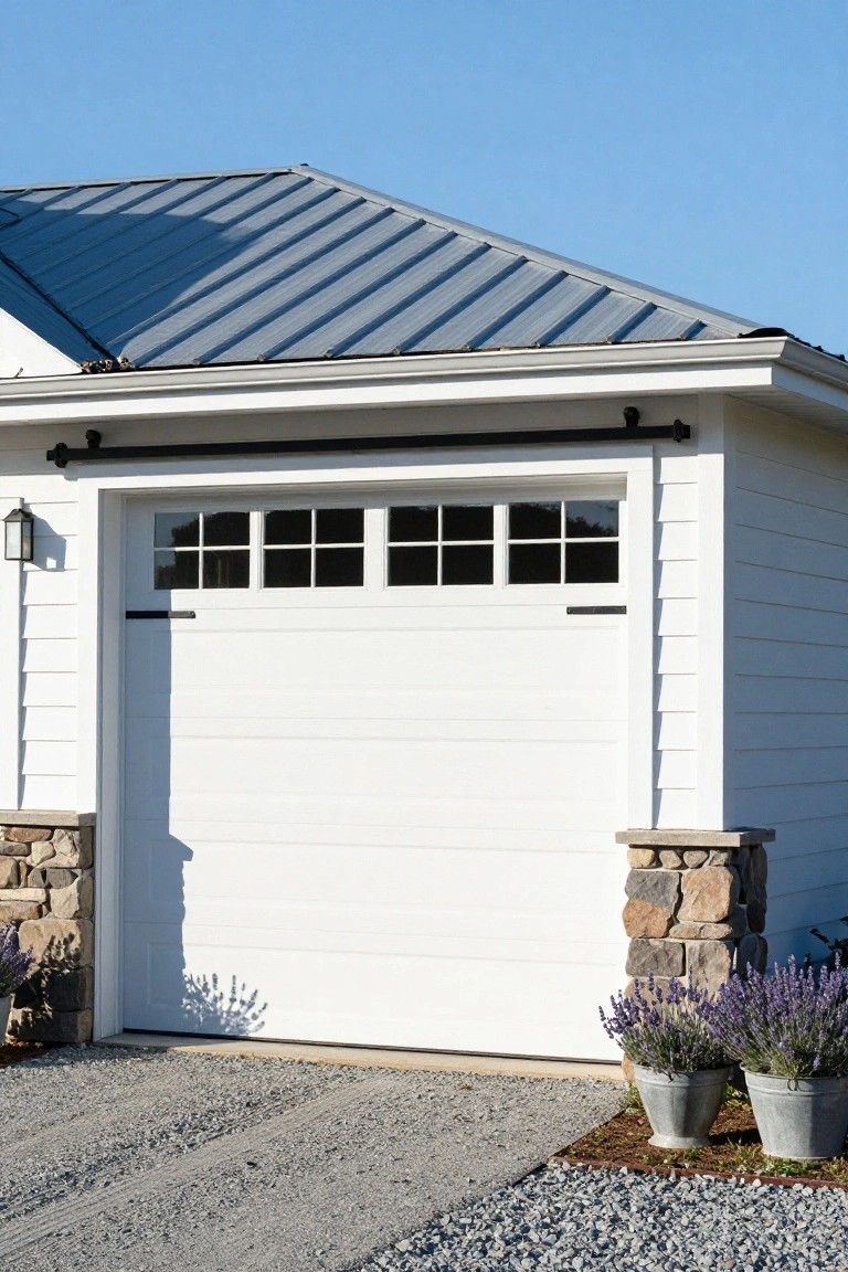 Crisp white garage walls and door with stone pillar bases and lavender plants