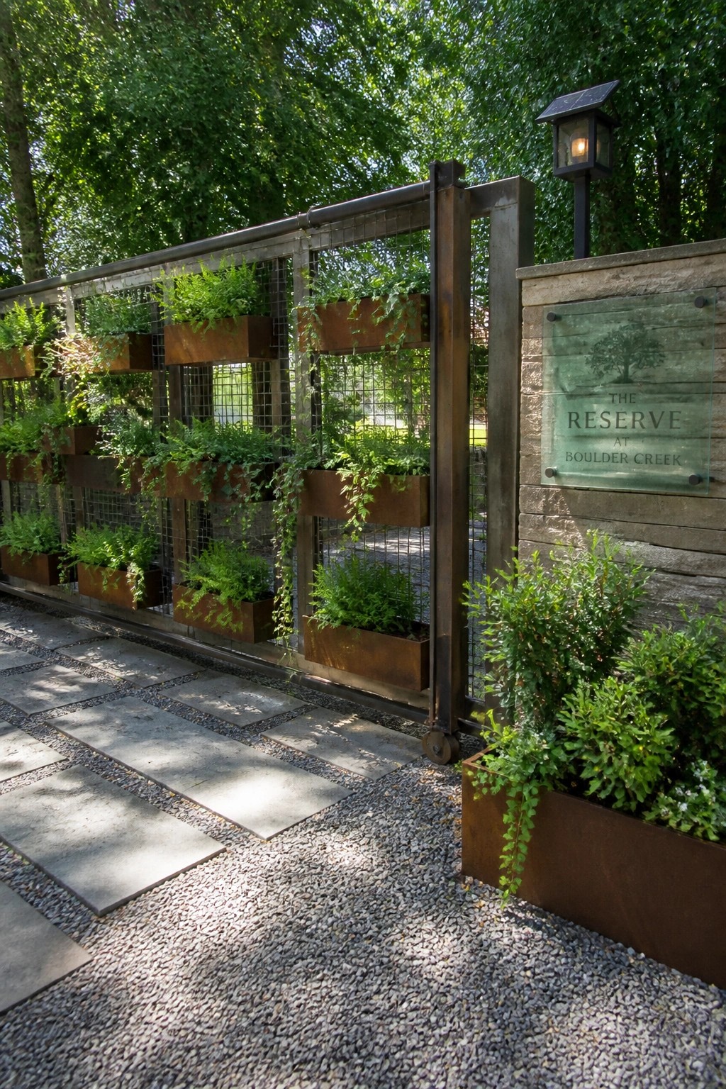 Rusted metal gate with cascading plants beside wooden sign for The Reserve at Boulder Creek.