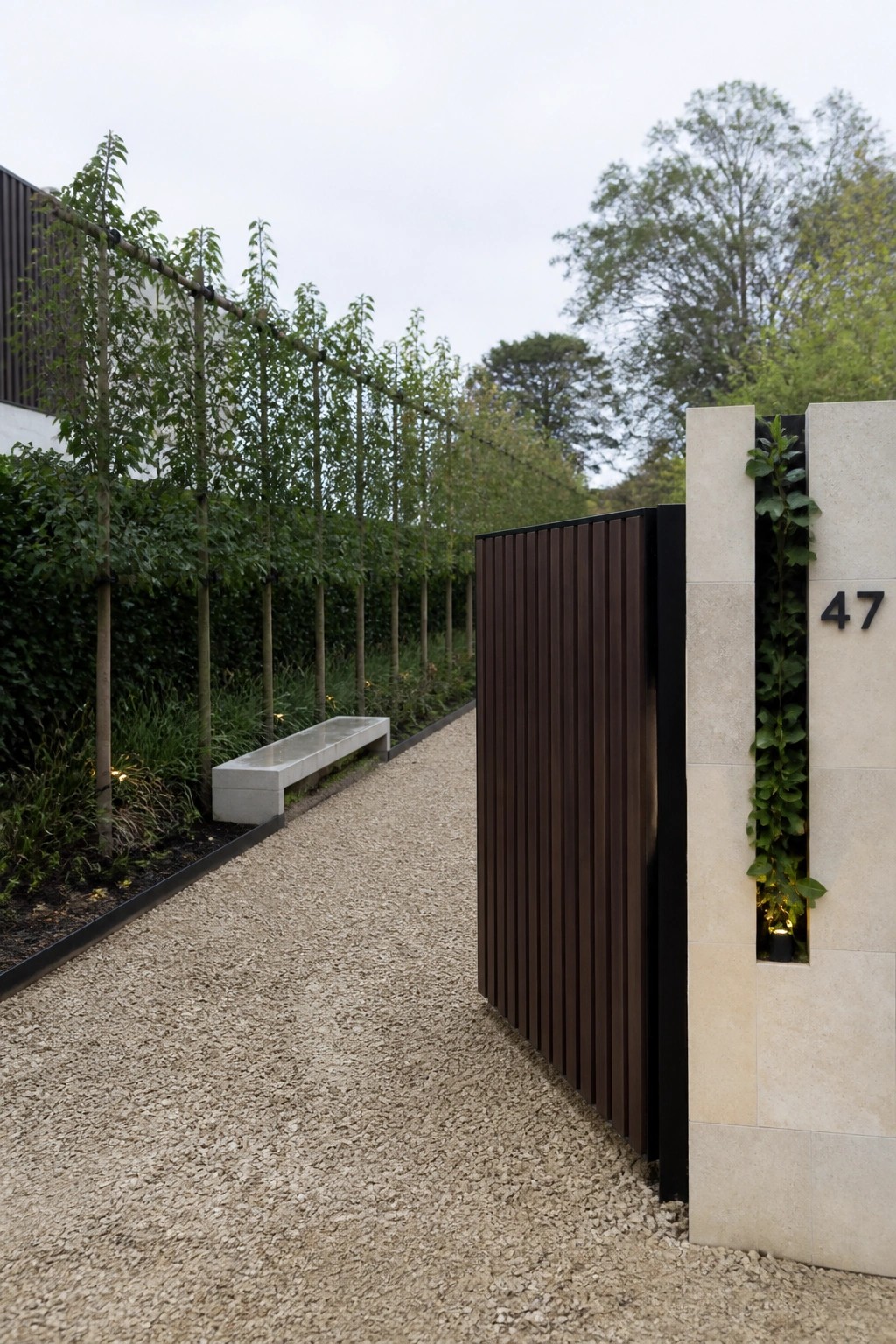 Modern slatted wooden gate beside stone pillar with number 47 and vertical plants