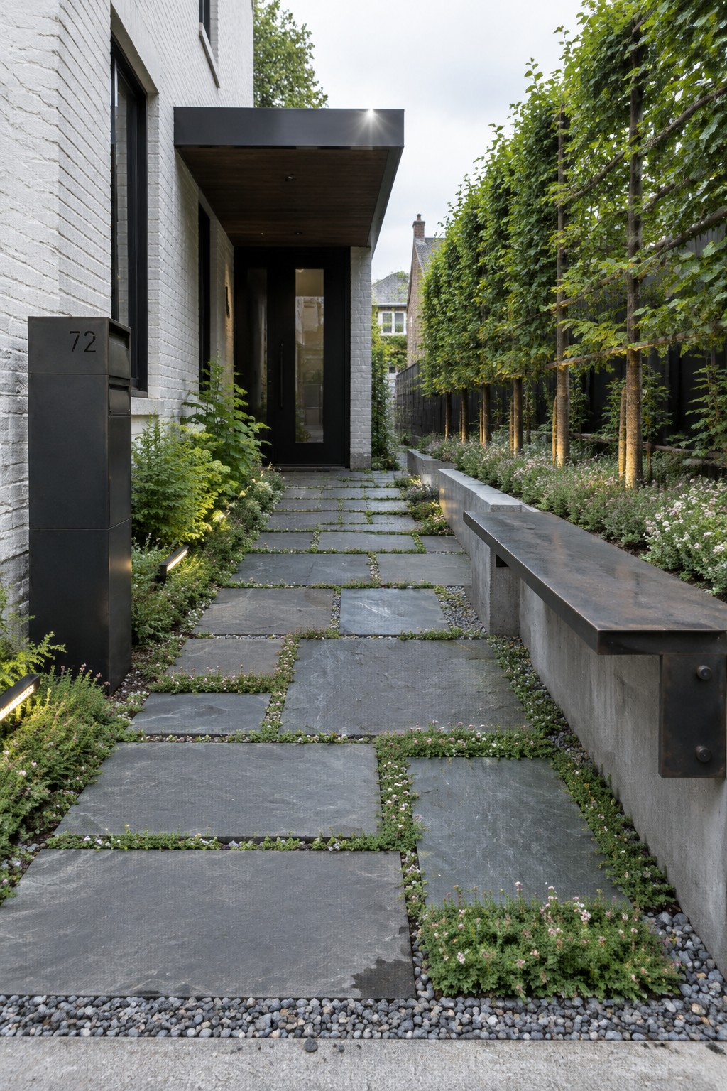 Modern stone pathway to black door of white brick home with garden bench